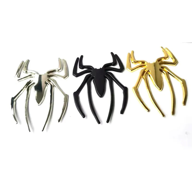 Three-dimensional metal spider bumper sticker in gold colour on vehicle surface