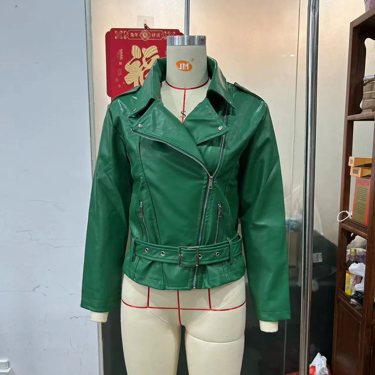 Black punk-style short jacket with a Peter Pan collar, lapel, and waist belt on a hanger.