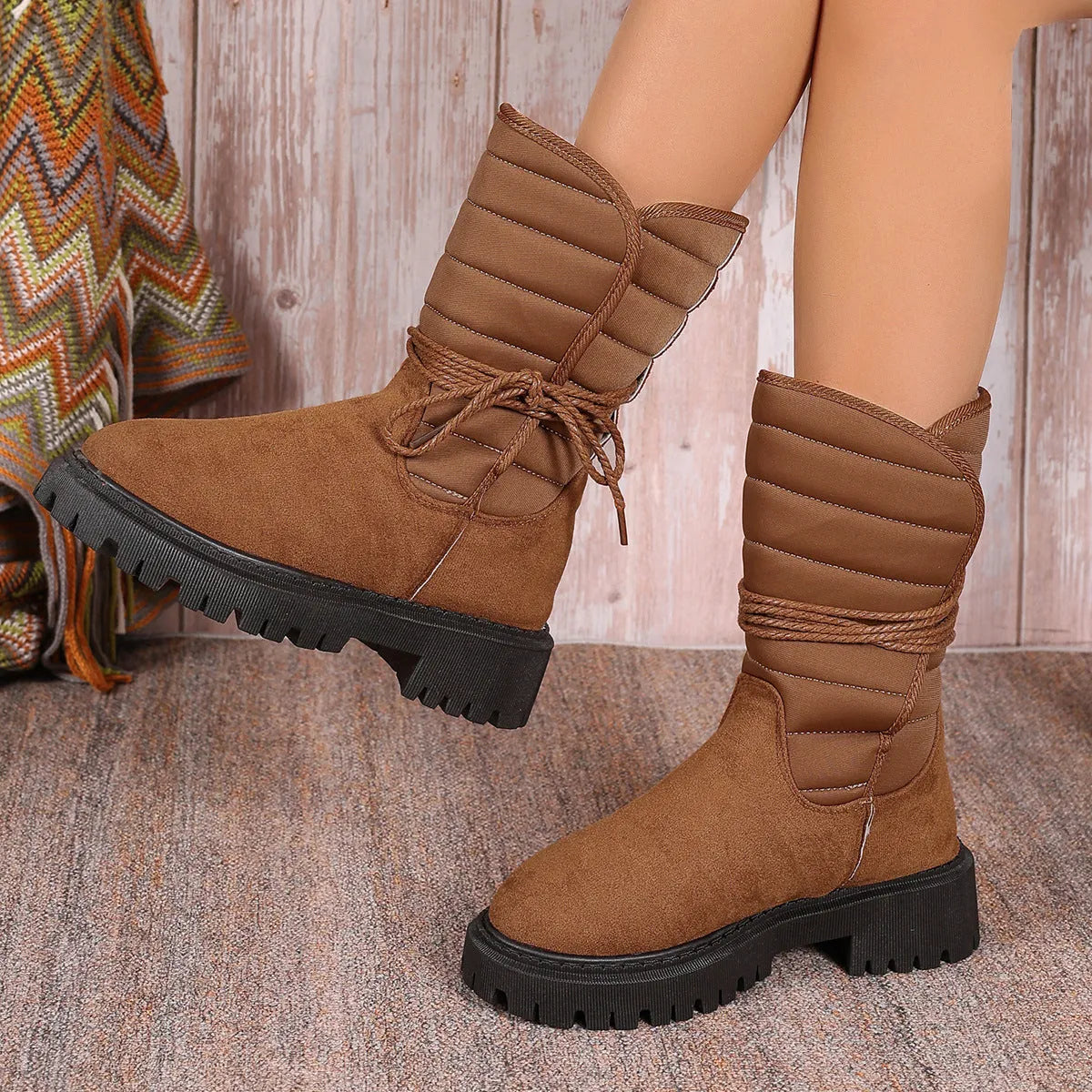 Women's black chunky heel snow boots with lace-up design and suede upper.