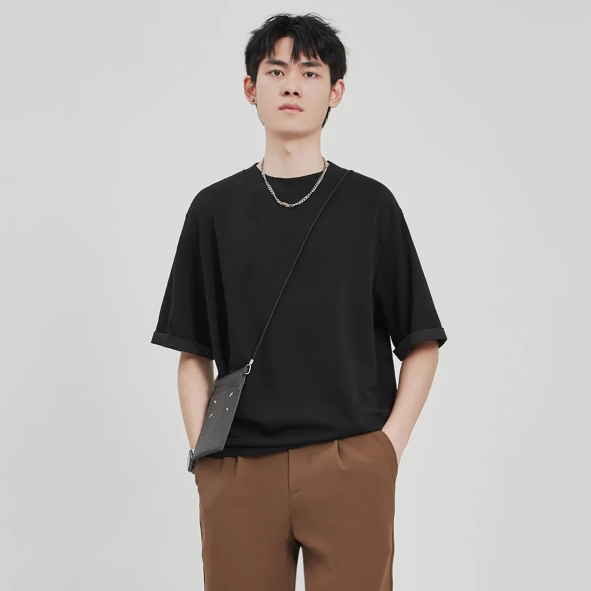 Men's brown loose drape knit casual T-shirt with short sleeves on a hanger.