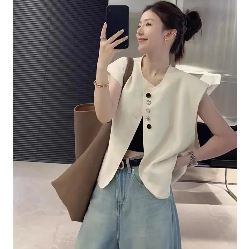 Women's loose fit sleeveless vest in beige and black, showing V-neck and pocket detail.