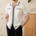 A black slim fit polo shirt with a lapel collar and short sleeves on a hanger.