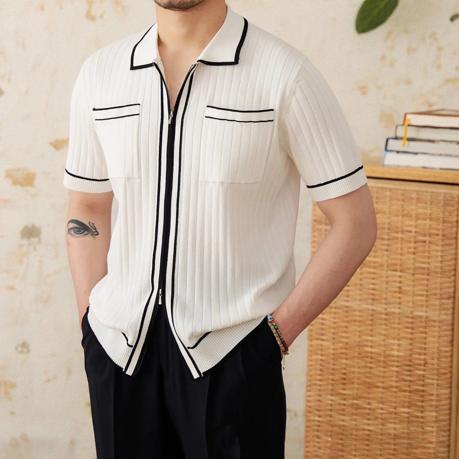 A black slim fit polo shirt with a lapel collar and short sleeves on a hanger.