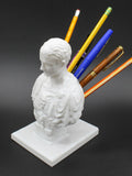 White synthetic resin pen holder with American creative character modelling on a desk.
