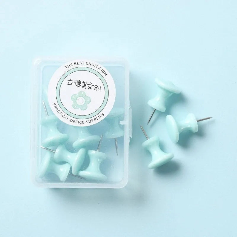 Plastic push pins in cherry blossom pink, mint green, and lavender, showing large and small sizes on a corkboard
