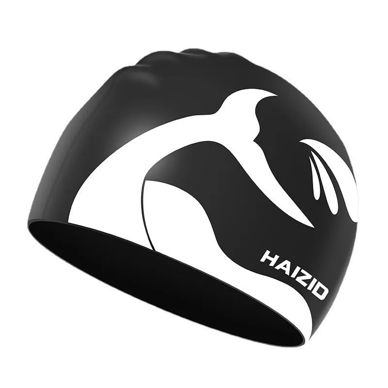 Silicone swimming cap with whale tail pattern and built-in ear protectors in black, blue, pink, and grey colours.