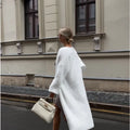 White knitted women's cardigan jacket with long sleeves and a loose, free-size fit
