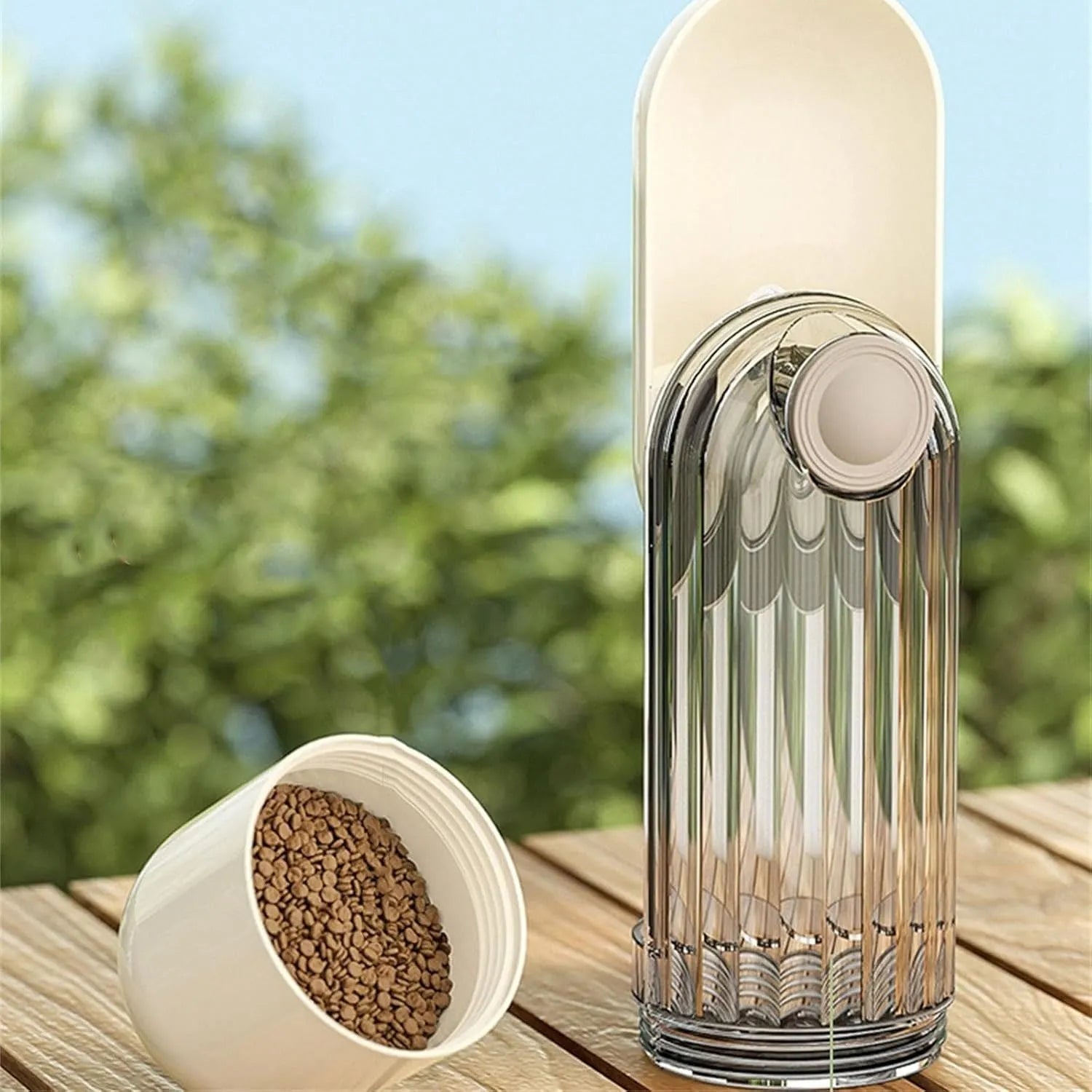 Beige and green foldable dog water bottle with food container, showing scale next to a dog's muzzle.