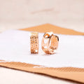 A pair of rose gold hollowed-out heart earrings on a white background, showing three-dimensional openwork detail.