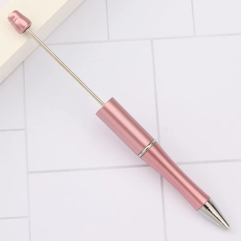 Colourful spinning ballpoint pen with plastic beads on a white background.