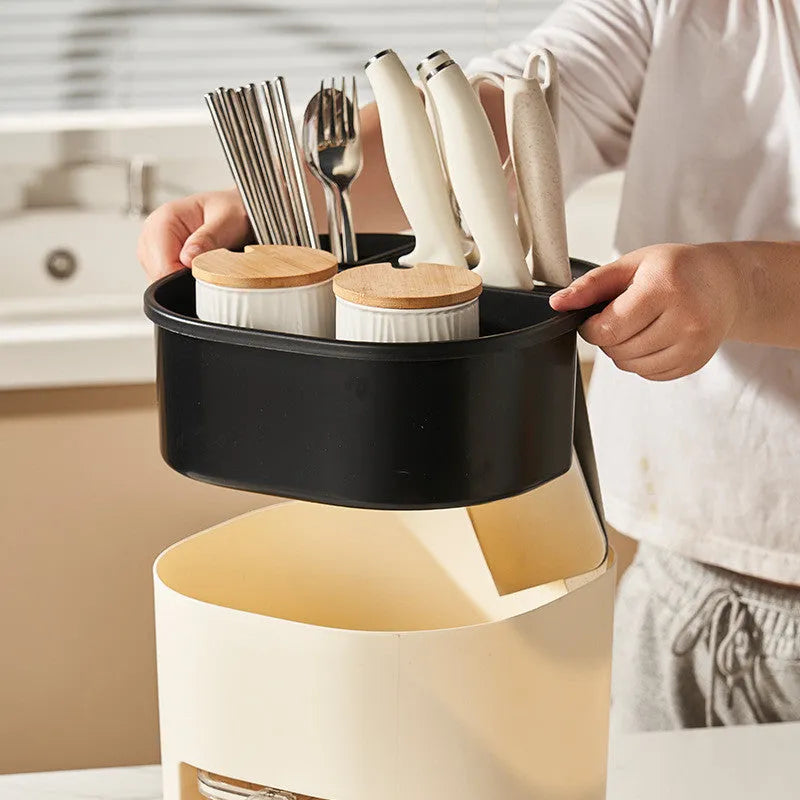 Plastic 360-degree rotating kitchen storage organiser with four compartments holding cutlery and a spice box