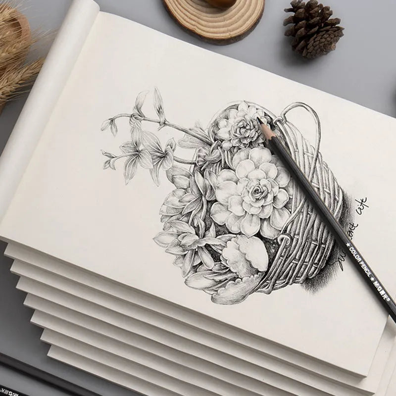 A4 blank draft notebook with picture colour cover, open to show unlined pages, placed on a desk with a pen.