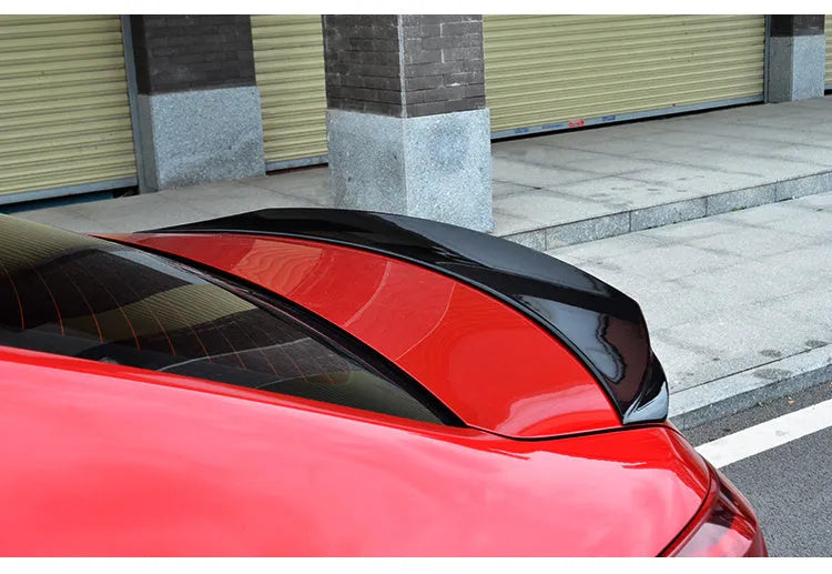 Large bright black fixed rear spoiler wing for Mazda 3 Axela Exela on car boot.