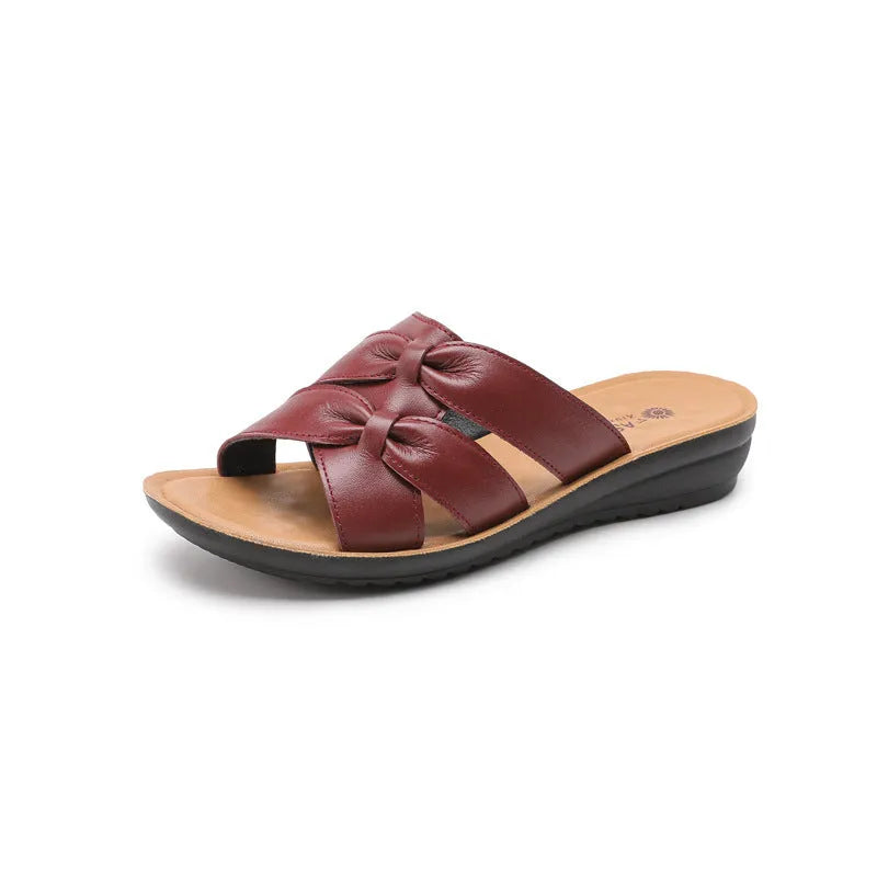 Beige women's cowhide slippers with a soft non-slip sole on a plain background