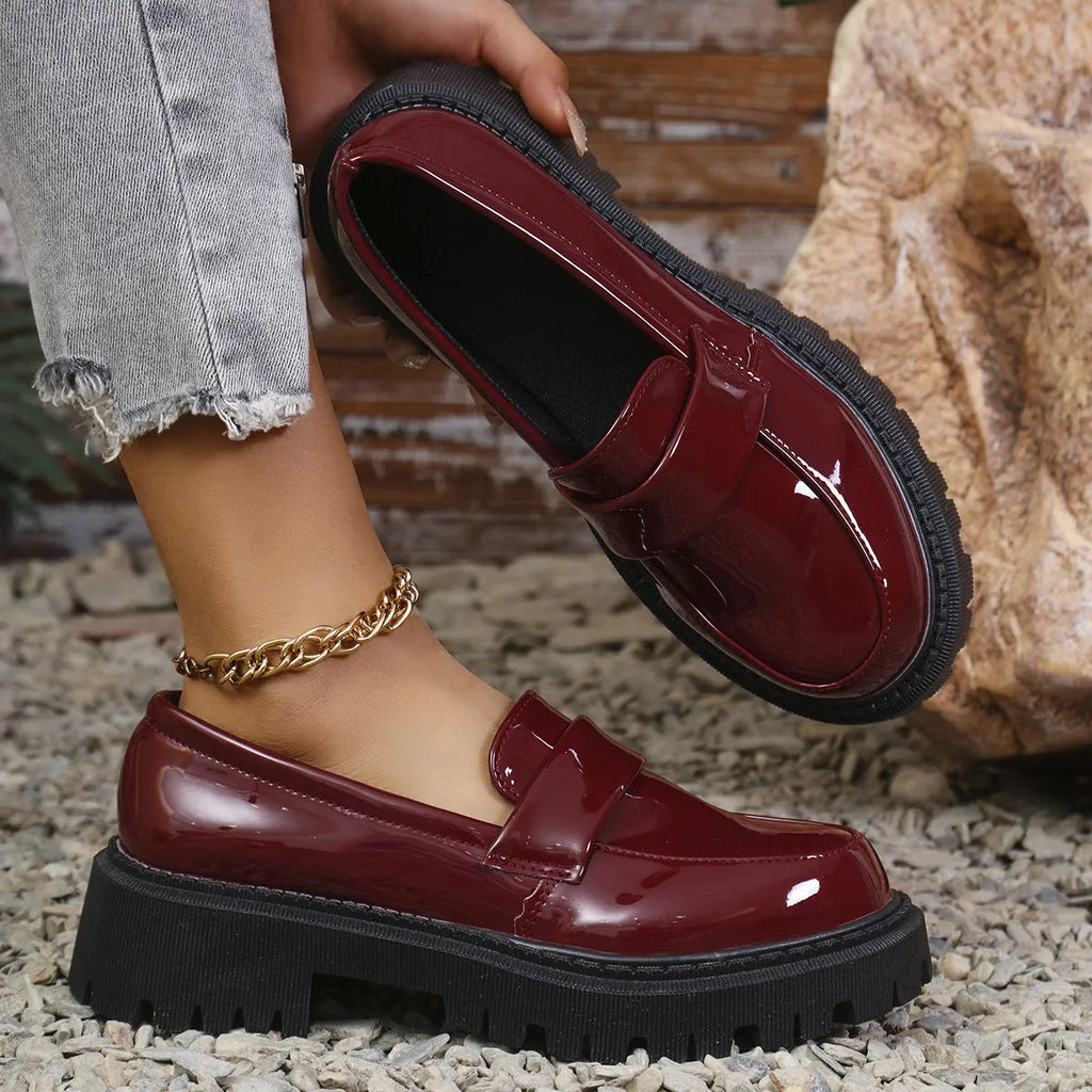Black slip-on loafers with a chunky platform heel and thick rubber sole.