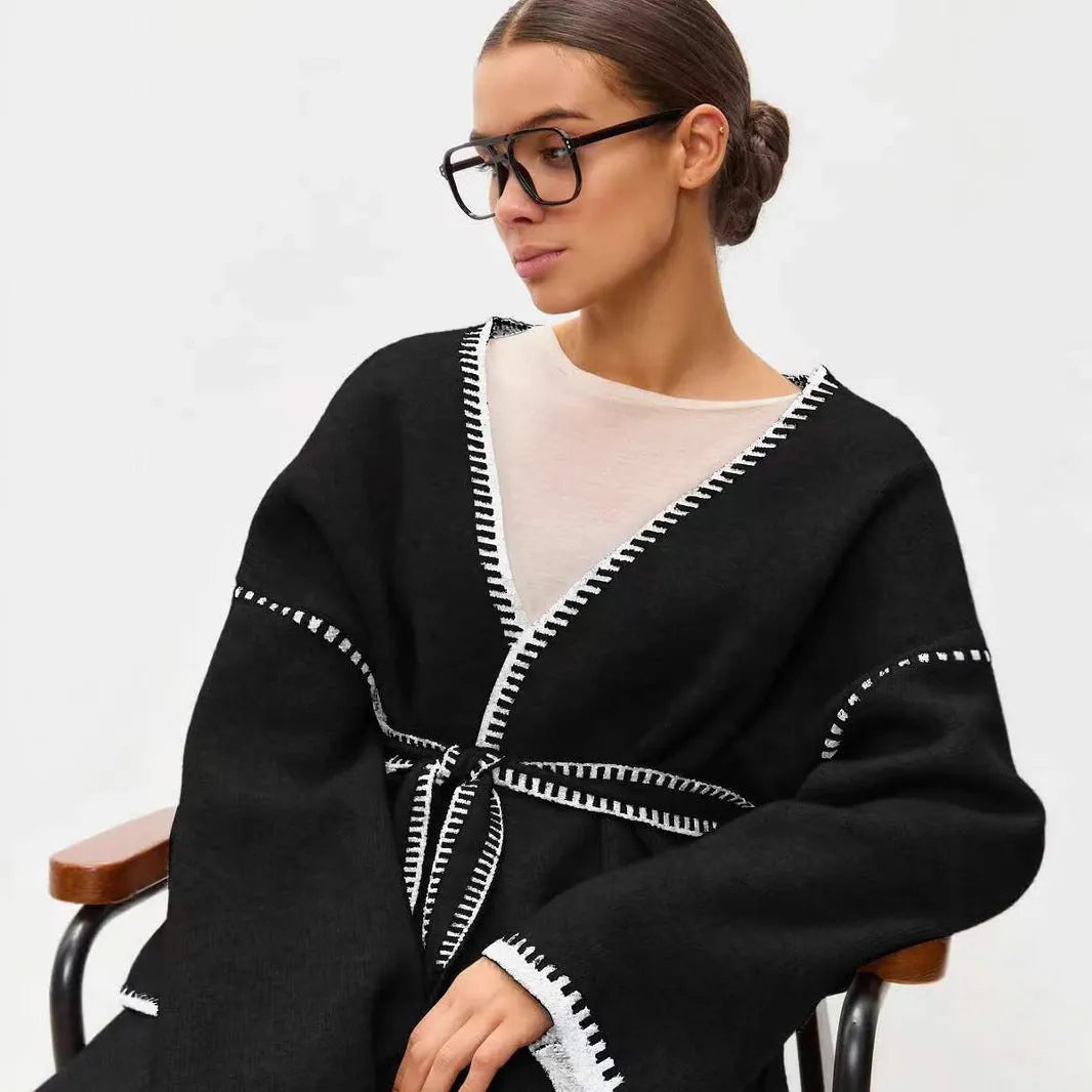 Loose black lace-up knitted cardigan on a hanger