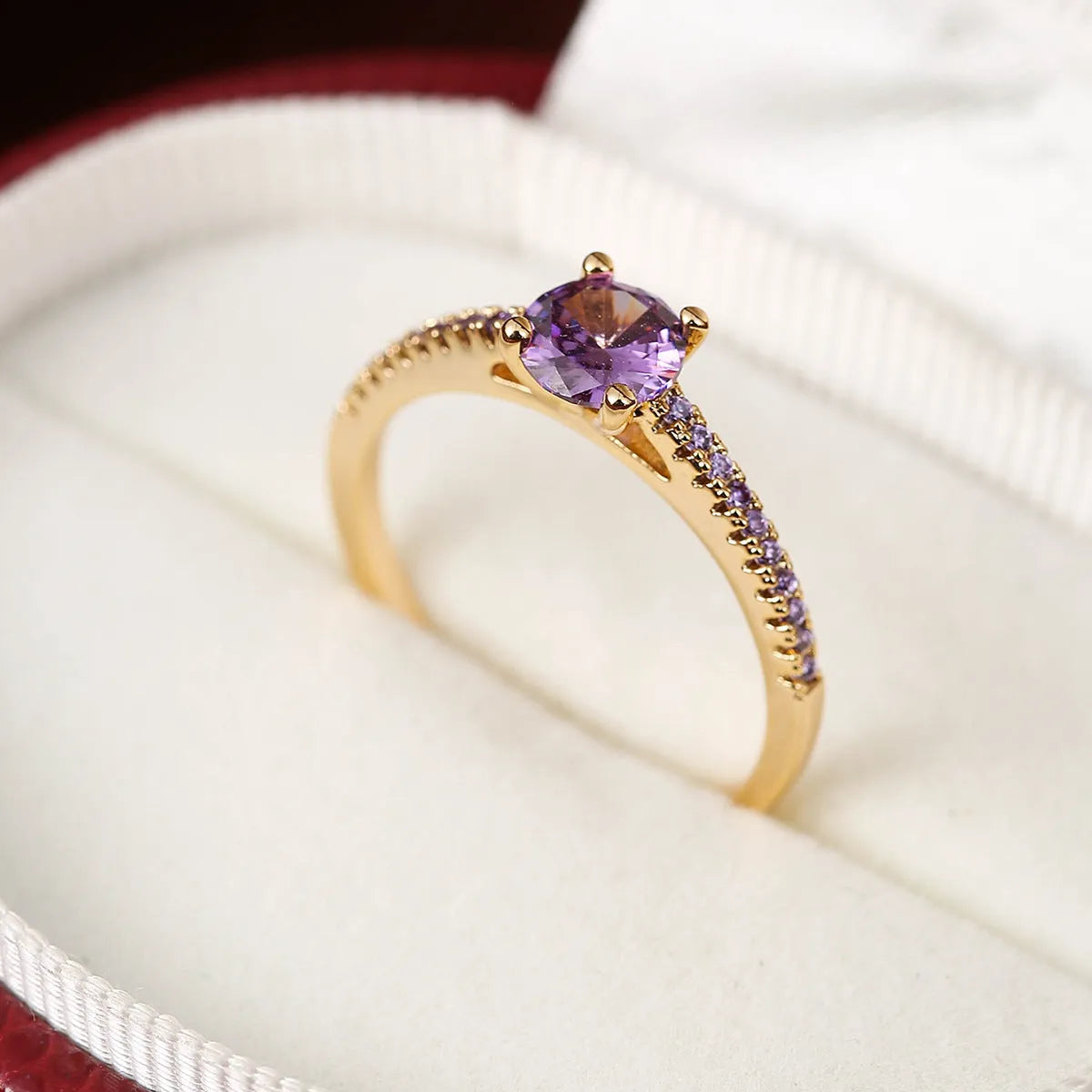Close-up of a hexagonal geometric copper ring with a central zircon stone in a gun black and purple electroplated finish.