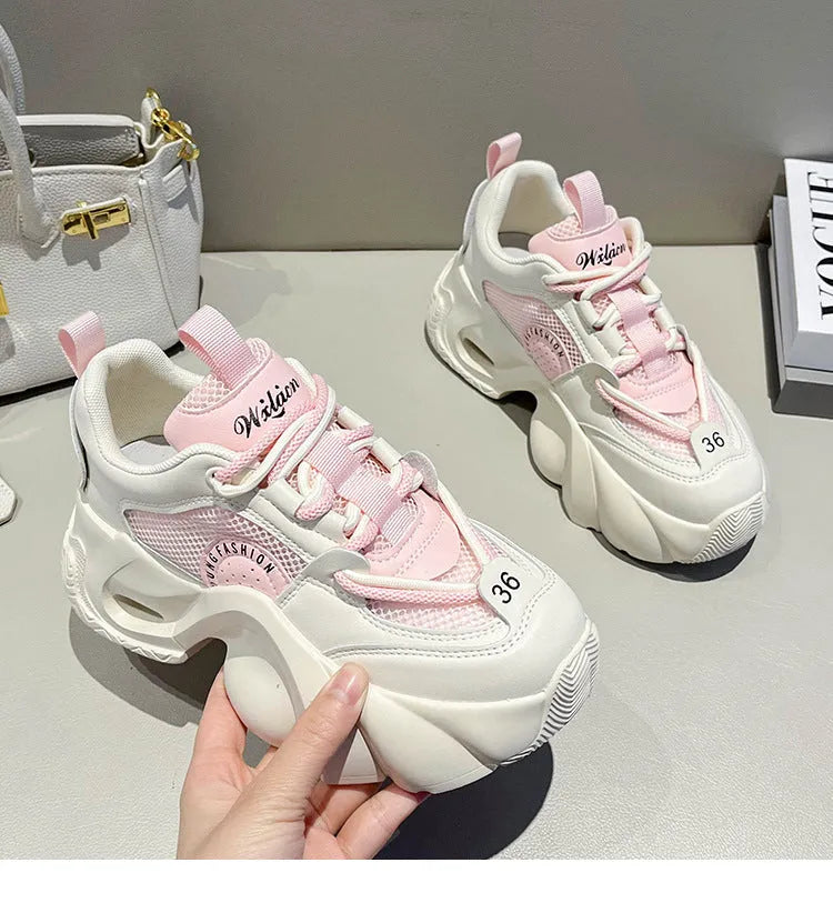 Women's beige sneakers with a thick sole, cross shoulder straps, and a mid heel.