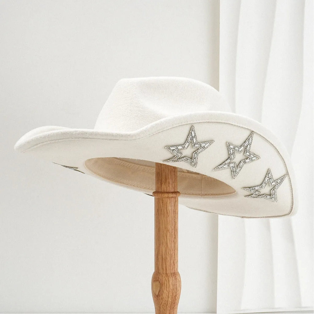 Beige woolen felt western style top hat with a conical crown and a silver hexagonal star decoration on the front.