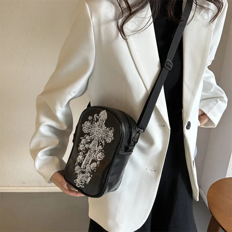 Black Halloween crossbody bag with orange pumpkin, white ghost, and black bat print, showing front zip and adjustable strap.