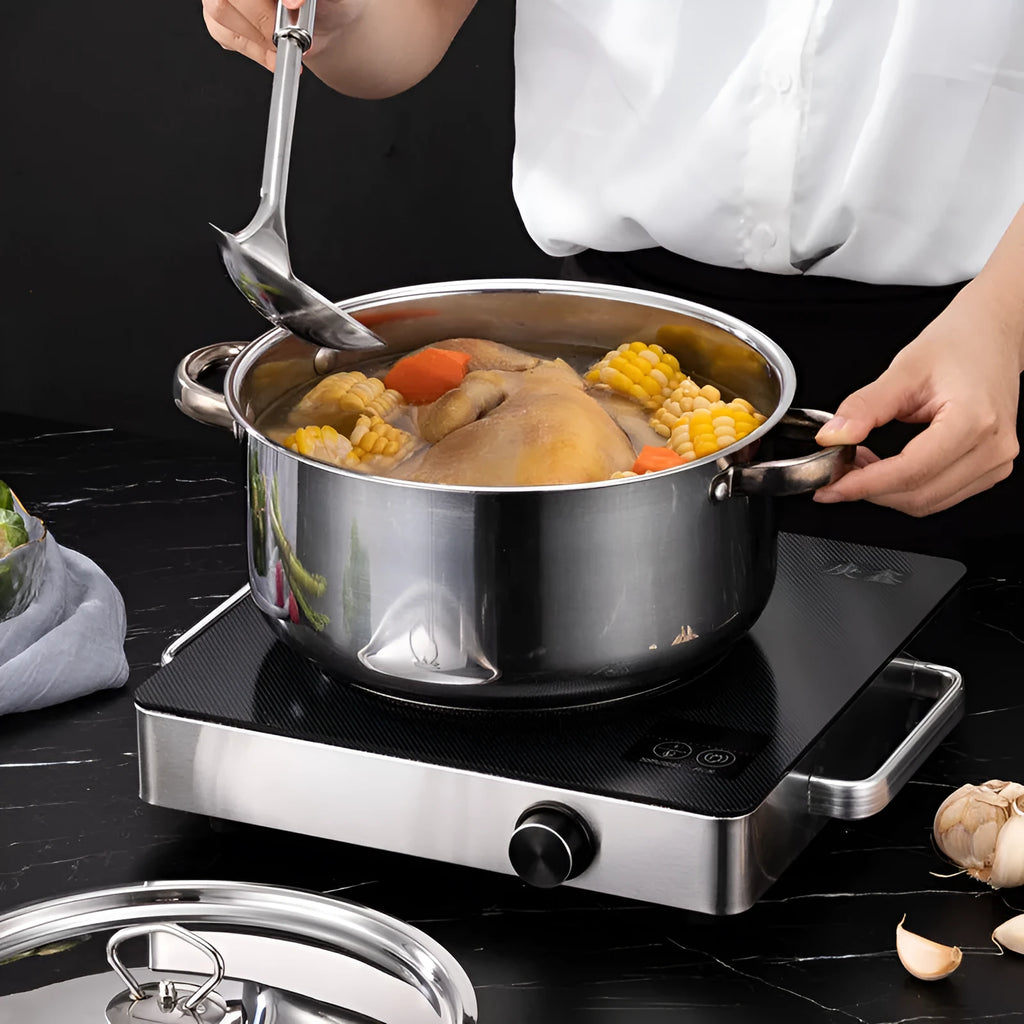 15-piece stainless steel non-stick cookware set with glass lids, spoons, and shovel on a table
