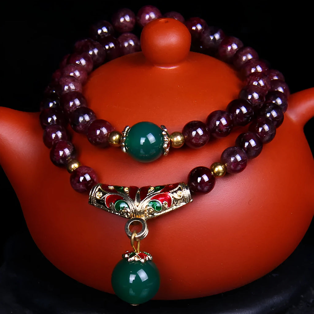 Natural red garnet 7mm bracelet with a golden toad charm on wrist, showing double ring clasp.