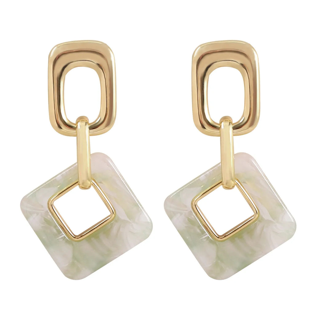 A pair of hollow geometric square copper earrings with chamfered corners on a white background.