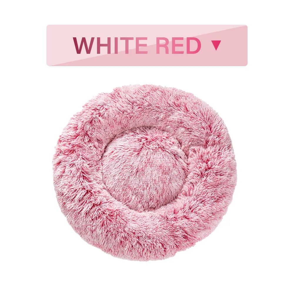 A fluffy, round donut-shaped dog bed with a raised rim in long plush fabric.