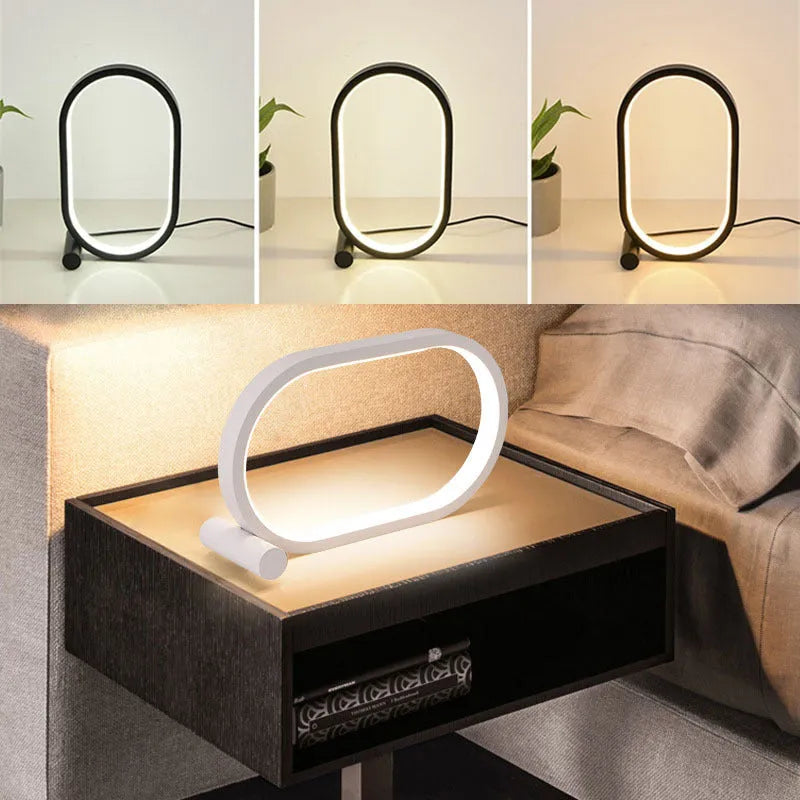 USB plug-in oval acrylic touch control night light with metal base, black finish, on a bedside table
