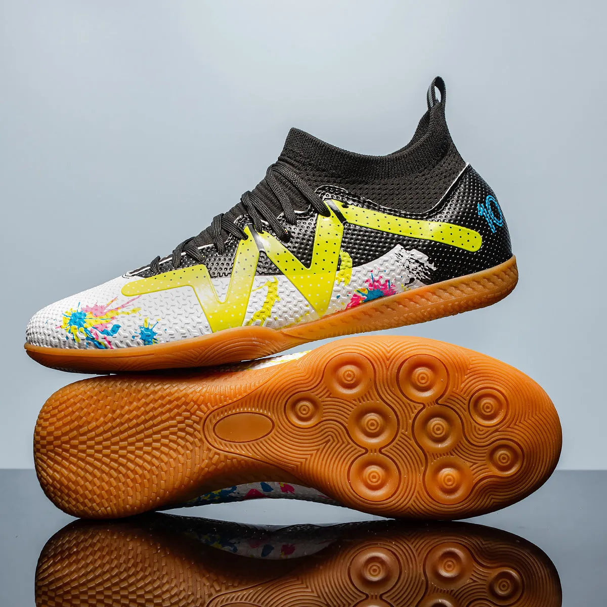 Low-top black and yellow football trainers with a spiked rubber sole and mesh detail.