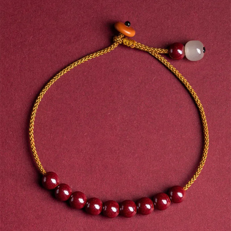 Hand-woven bracelet made of red cinnabar and raw Hetian Jade in a simple geometric shape.