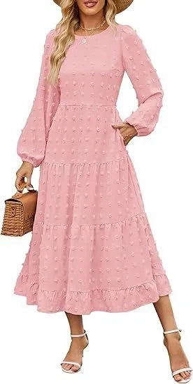 A woman wearing a beige high waist long sleeve dress with ruffled sleeves, a round neck, and a solid colour design.