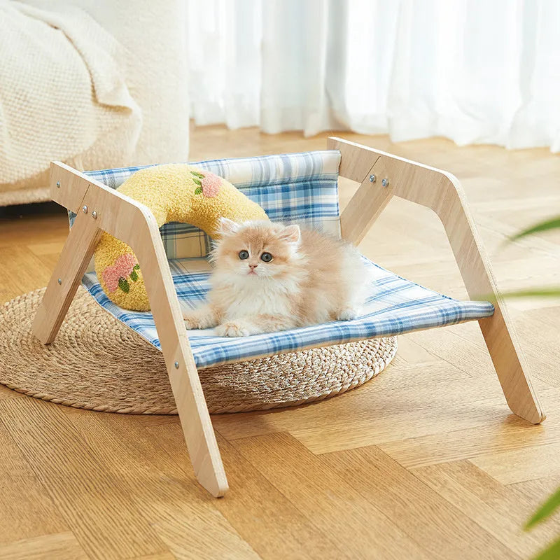 Elevated wooden cat bed with blue cloth hammock in beach chair style