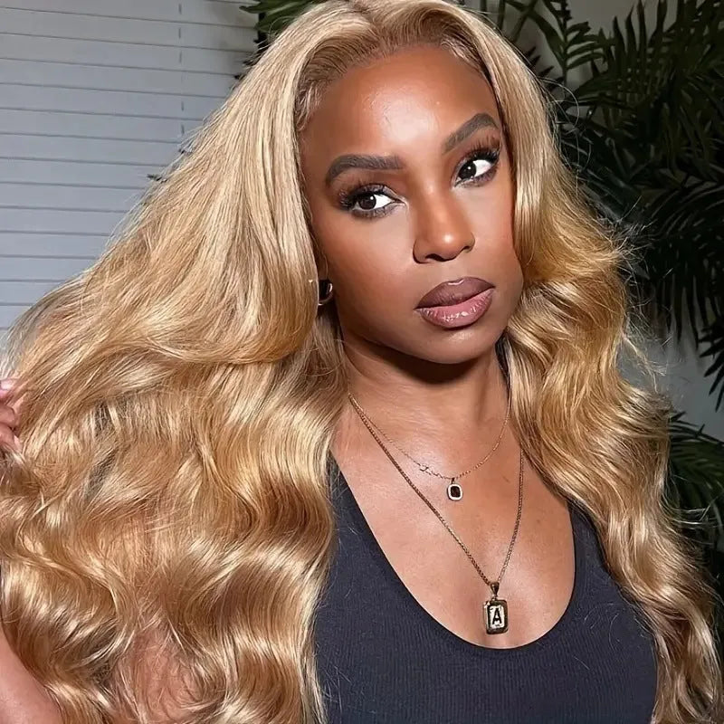 Long golden light brown synthetic wig with big curly waves and side bangs laid flat.