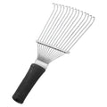 Stainless steel dematting brush and grooming rake for horses and pets on a wooden surface.