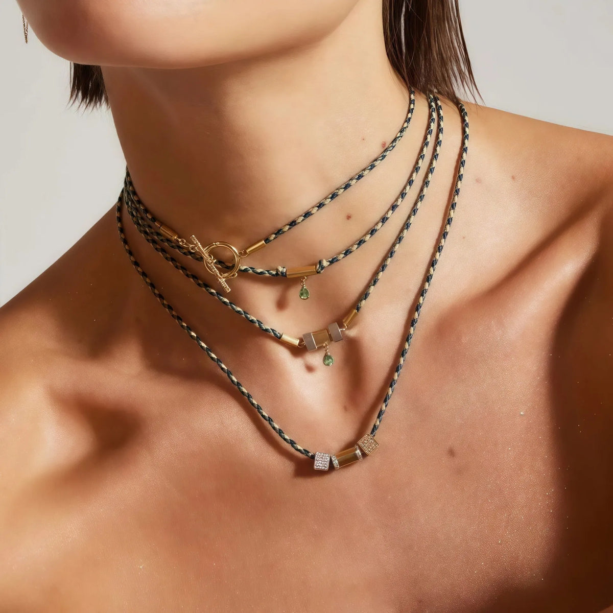 Gold plated copper twin necklace with braid rope chain and emerald-coloured geometric ellipse pendant for women