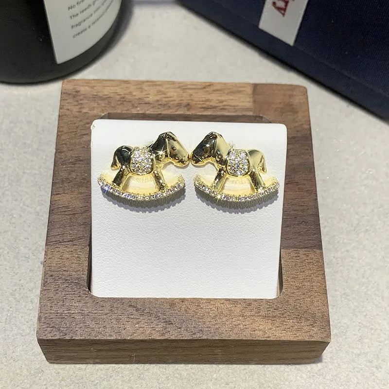 Diamond studded rocking horse earrings in gold and silvery metal finish for women