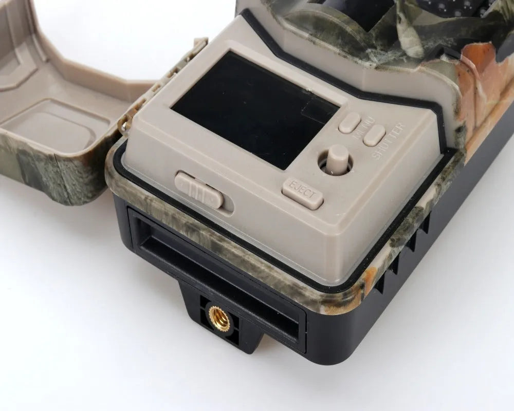 Compact camouflage trail camera with infrared LEDs, showing front display and lens.