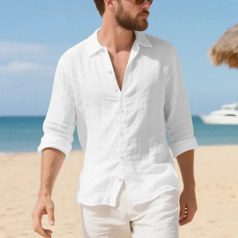 A man wearing a loose-fit light blue linen casual shirt with a non-iron finish, buttoned front and standard collar.
