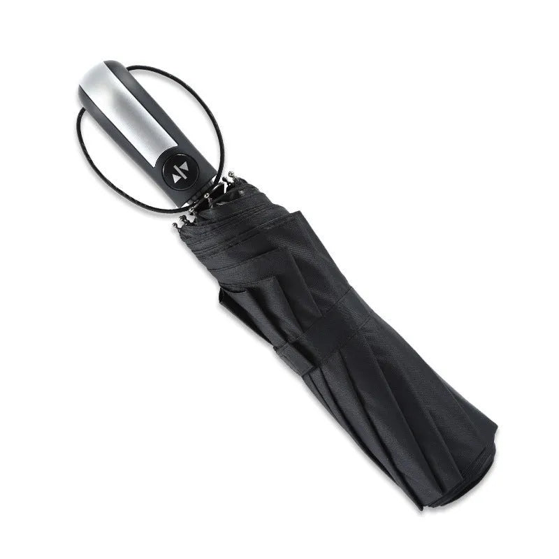 Black automatic open triple-folding business umbrella with a ribbed rubber handle, shown deployed.