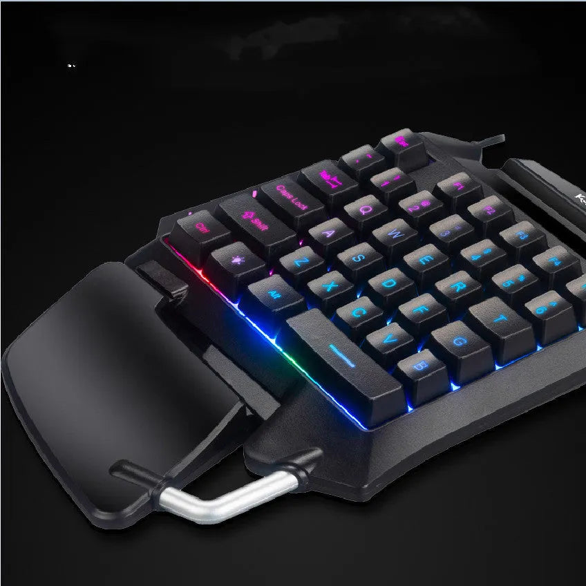 Black left-hand throne one-handed gaming keyboard with shortcut keys and wrist rest on a desktop.