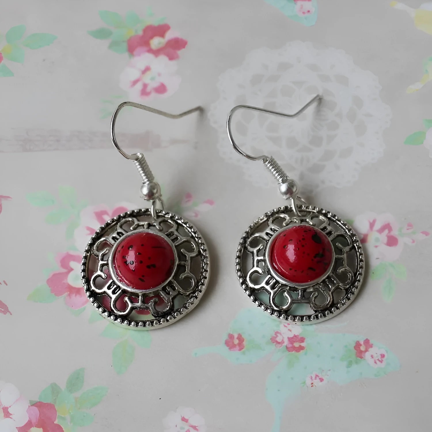 A pair of handmade geometric flower disk earrings in Tibetan silver and turquoise with ethnic patterns.