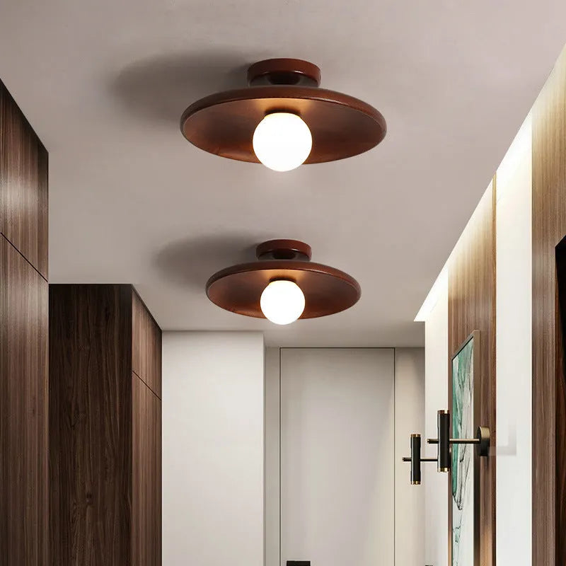 Modern minimalist solid wood and glass ceiling lamp in a hallway setting.