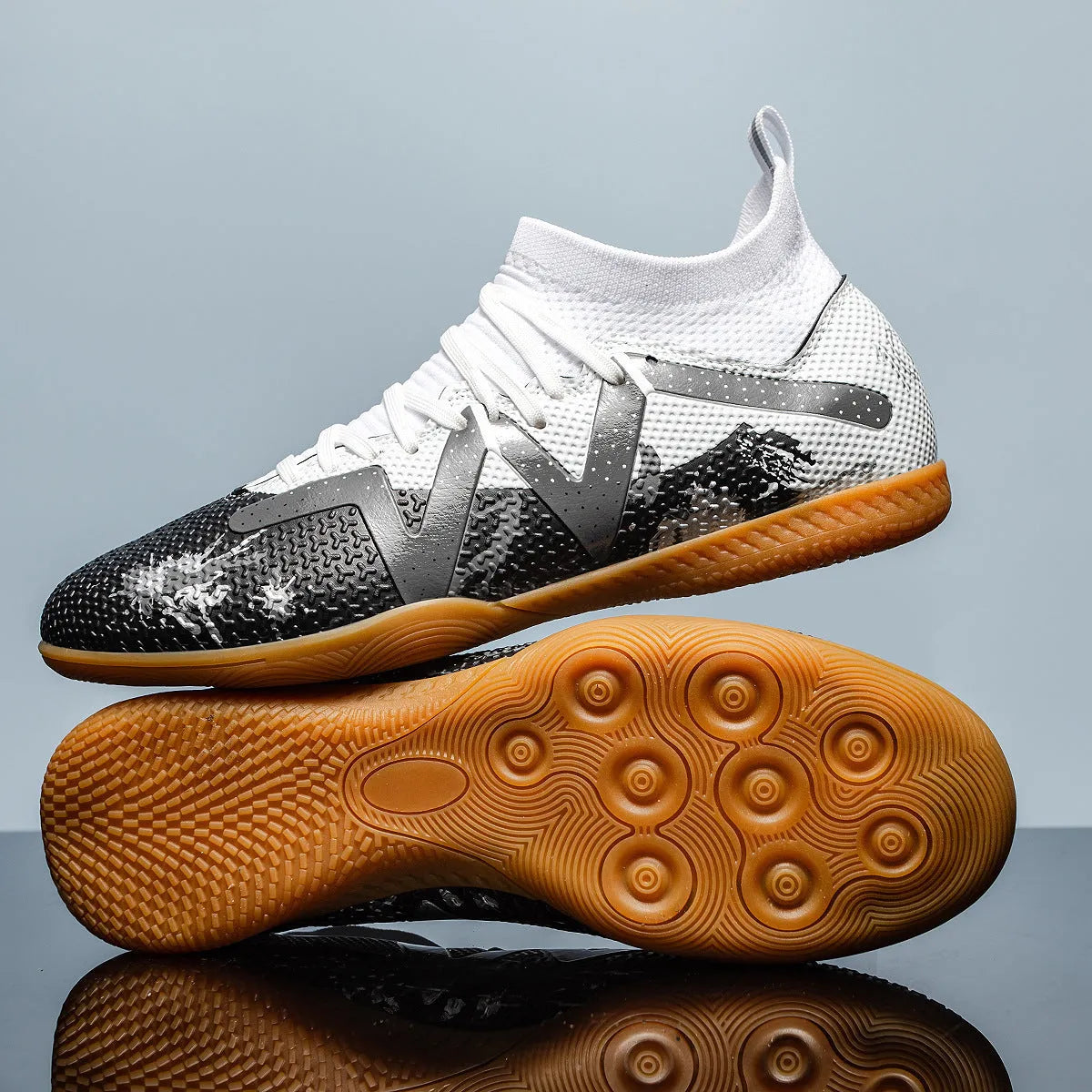 Low-top black and yellow football trainers with a spiked rubber sole and mesh detail.
