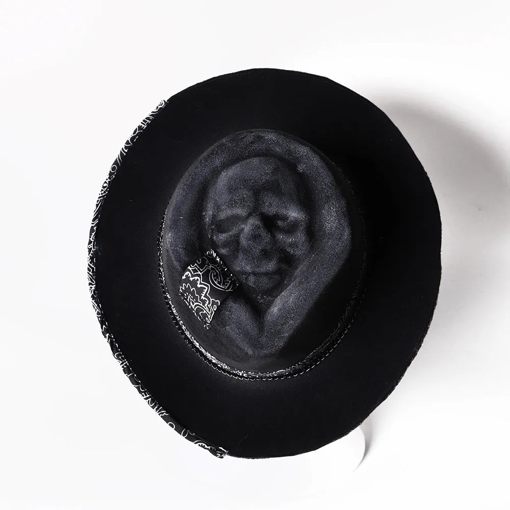 Handmade denim-blue wool felt skull hat with embroidered white skull on front and structured conical crown.