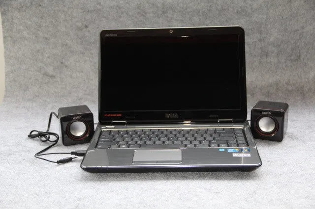 Small black square USB-powered 2.0 computer speaker on a desk.