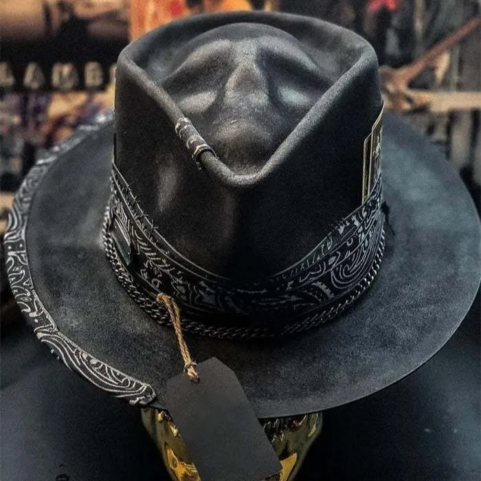 Handmade denim-blue wool felt skull hat with embroidered white skull on front and structured conical crown.