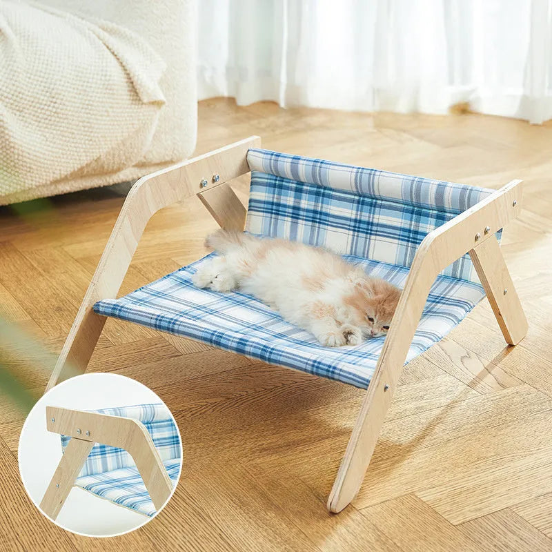 Elevated wooden cat bed with blue cloth hammock in beach chair style