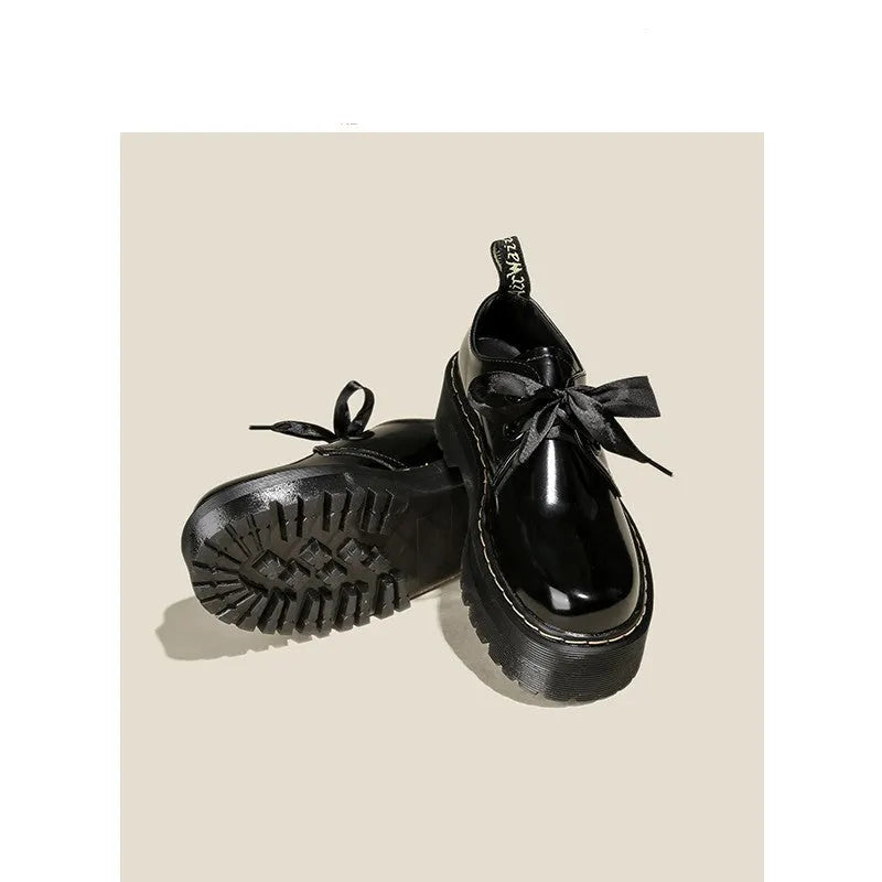 Black and white women's thick-soled leather shoes with ribbon cross straps and laces.