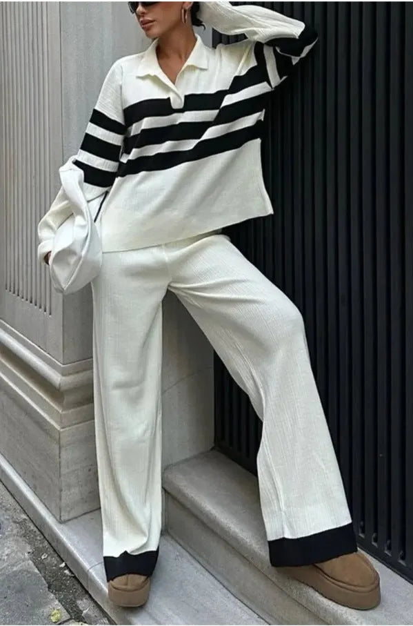 Women's black and white striped knitted two-piece set with polo collar top and full-length trousers.